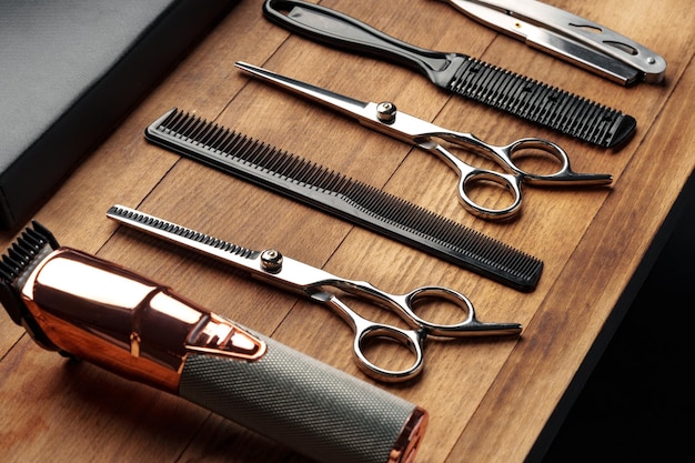 Berufliche Friseurwerkzeuge, die auf einer Holzoberfläche für die Friseursitzung für Männer ausgelegt sind