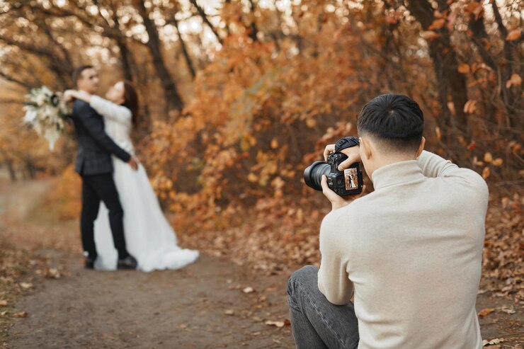 Foto beruflicher hochzeitsfotograf, der das braut- und bräutigam im herbst in der natur fotografiert