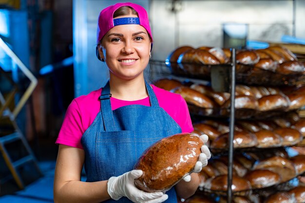 Berufsbäcker hält Brot in den Händen. Industrielle Brotproduktion. Nahaufnahme.