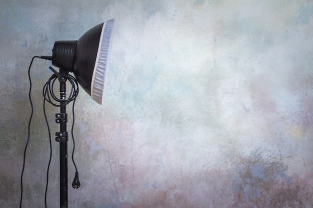 Berufsbeleuchtungausrüstung im Fotostudio auf dem ursprünglichen grauen Hintergrund