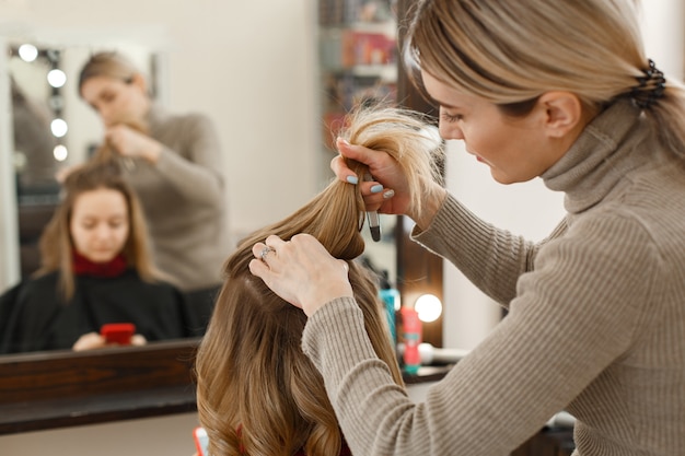 Berufsfriseur, der mit kunden im salon arbeitet