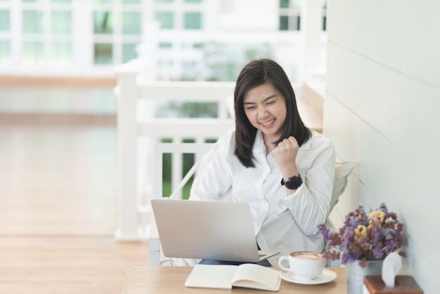 berufstätige Frauen, die mit Laptop arbeiten und mit der Nachfolge im Café glücklich sind