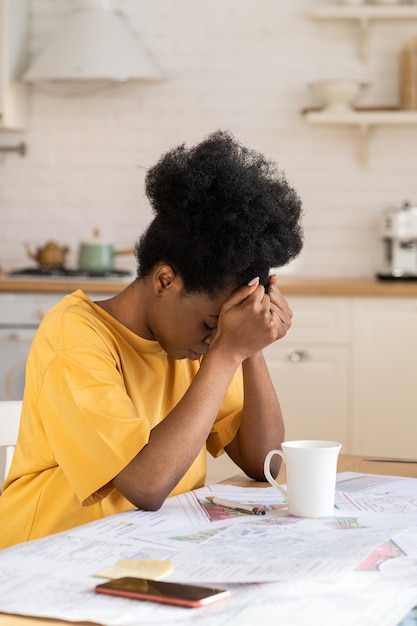 Überwältigte junge Frau erschöpfte Überarbeitung des Afro-Designers, der die Arbeit mit der Projekt-Fernbedienung zu Hause satt hat