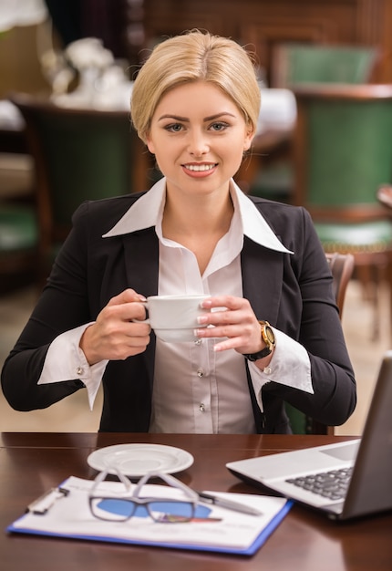 Überzeugte Geschäftsfrau, die am Tisch im Café sitzt.