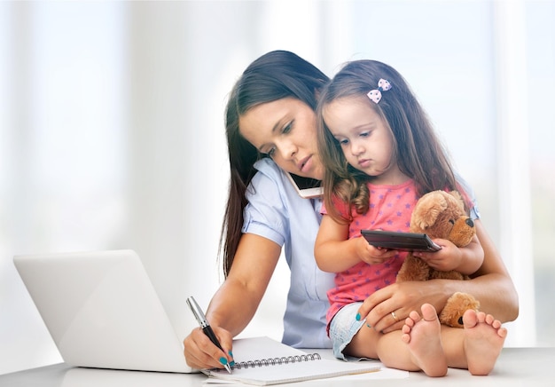 Beschäftigte Frau, die versucht zu arbeiten, während sie babysittet