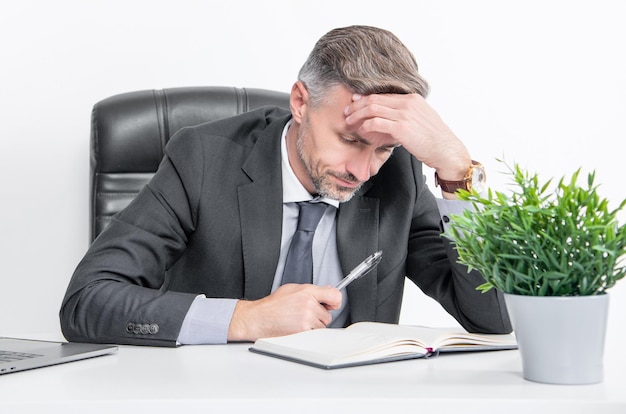 Foto beschäftigter, reifer, überarbeiteter geschäftsmann sitzt im geschäftsbüro