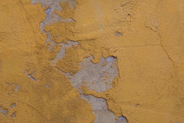 Beschaffenheit der alten rustikalen Wand bedeckt mit gelbem Stuck