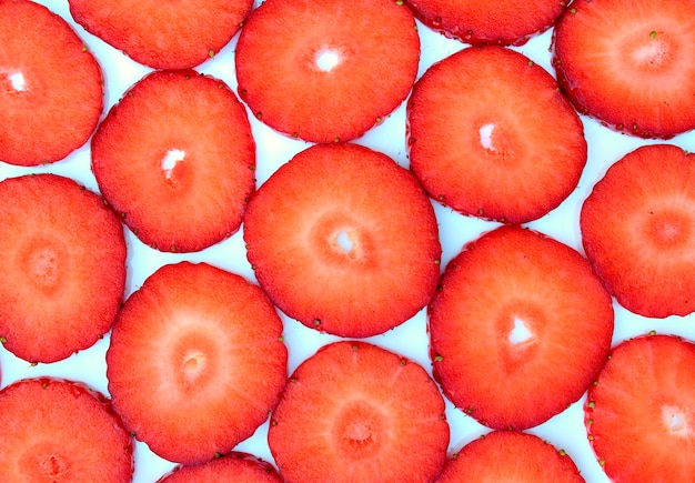 Beschaffenheiten und fruchtiges Konzept: Muster mit Rotschnitterdbeeren auf einem weißen Hintergrund.