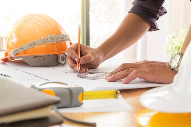 Foto beschnittene architekturhände zeichnen einen bauplan im büro