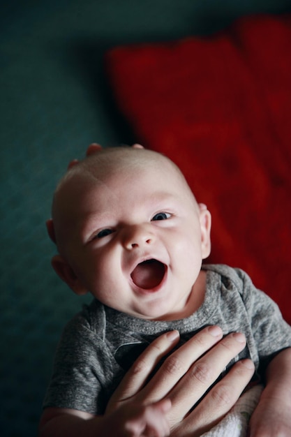 Beschnittene Hände halten den Jungen zu Hause