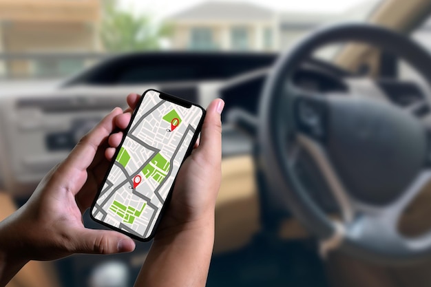 Beschnittene Hände mit einer Karte im Handy während einer Fahrt