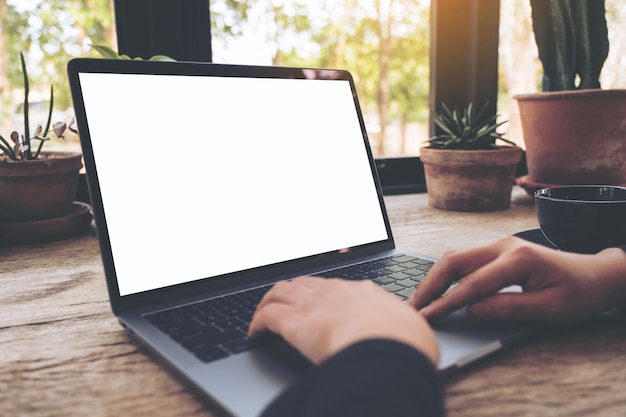 Beschnittene Hände mit Laptop am Tisch