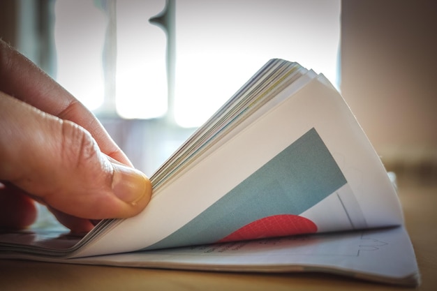 Foto beschnittene hand hält ein buch auf dem tisch