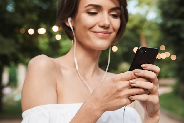 Beschnittenes Bild des glücklichen jungen Mädchens, das Musik hört