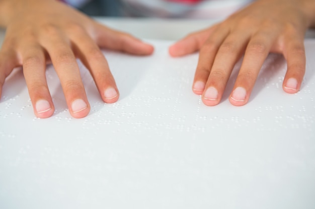 Beschnittenes Bild des Kindes, das Braillebuch liest
