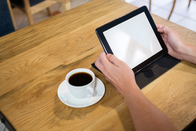 Beschnittenes Bild des Mannes unter Verwendung der digitalen Tablette mit leerem Bildschirm im Café