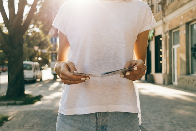 Beschnittenes Bild einer jungen Frau, die eine Papierkarte betrachtet