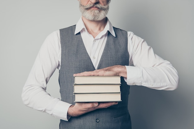 Foto beschnittenes foto des positiven klugen klugen alten mannes, der einen stapel bücher formt