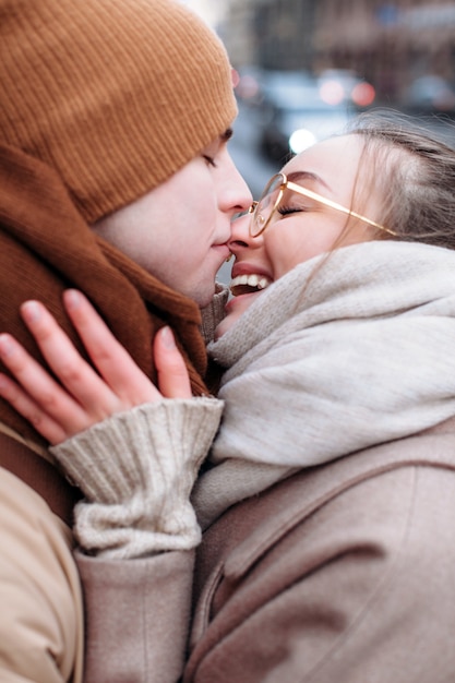 Foto un beso closeup retrato de la hermosa pareja de enamorados posando al aire libre en invierno frío.