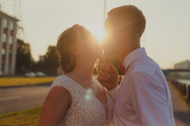 Un beso de los novios al atardecer Artículo de boda Una pareja feliz Fotos de amor para productos impresos