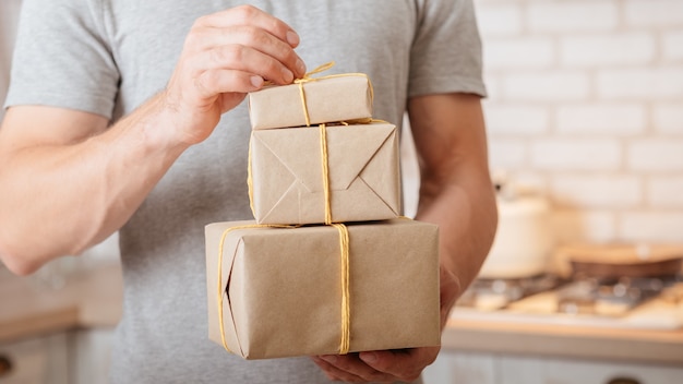 Besonderer Tag. Der abgeschnittene Schuss eines Mannes erhielt Geschenke und öffnete handgefertigte Papierpakete.