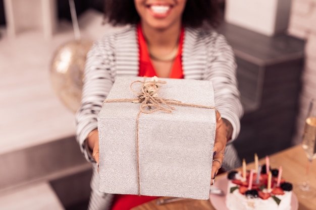 Besonderes Geschenk. Selektiver Fokus einer schönen Geschenkbox, die einer angenehm netten Frau gegeben wird