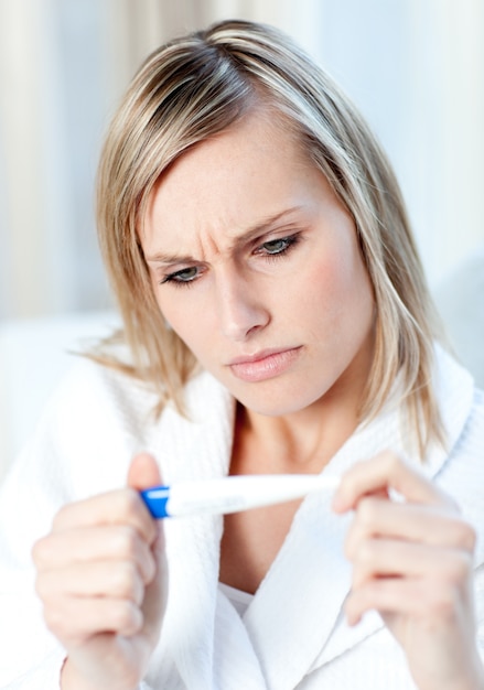 Besorgte Frau, die die Ergebnisse eines Schwangerschaftstests herausfinden