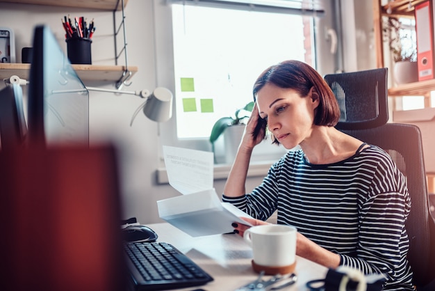 Besorgte Frauenlesepost im Büro