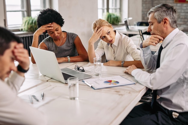 Foto besorgtes geschäftsteam, das probleme während eines meetings im büro hat