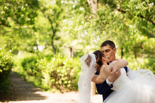 Foto besos amorosos recién casados, novios besándose en el parque