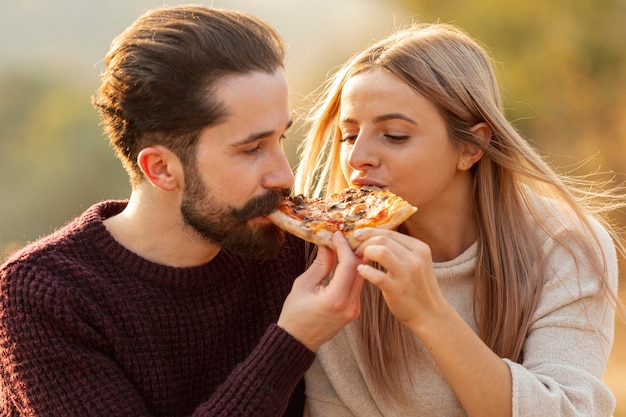 Beste Freunde, die zusammen eine Nahaufnahme der Pizza essen