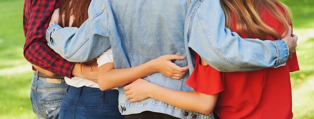 beste Freunde für immer. Gruppe junger Männer und Frauen, die sich zusammen umarmen. Freundschaft und Teamwork