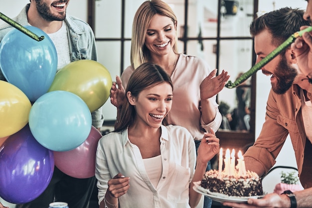 beste Geburtstagsfeier! Gruppe glücklicher Menschen, die unter Freunden Geburtstag feiern und lächeln