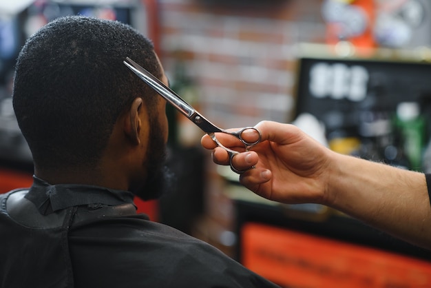 Besuch eines Friseursalons Afroamerikaner in einem stilvollen Friseurladen