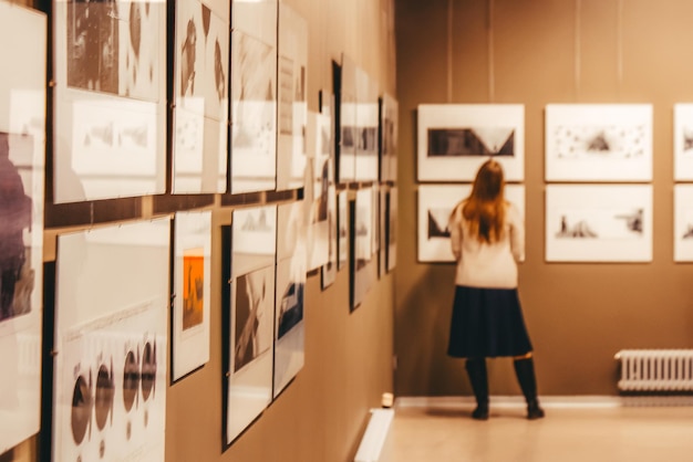 Besucher einer klassischen Kunstgalerie oder eines Museums sehen sich die Exponate an. Menschen oder Touristen sehen sich die Gemälde in der Ausstellung an. Männer und Frauen erfreuen sich an Kunstwerken