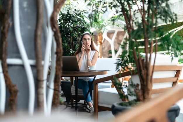 Besucher eines gemütlichen Internetcafés, der auf einem Smartphone spricht