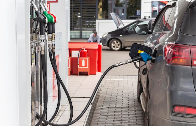 Betanken des Autos mit Benzin oder Dieselkraftstoff an der Tankstelle Schwarzes Auto, das betankt wird