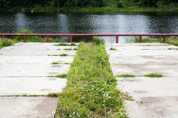 Betonplatten als Teil der Straße am Eingang zum See oder Flussufer