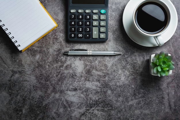 Betontisch mit Kaffee mit Bürozubehör. Draufsicht der Kaffeetasse auf Betontisch