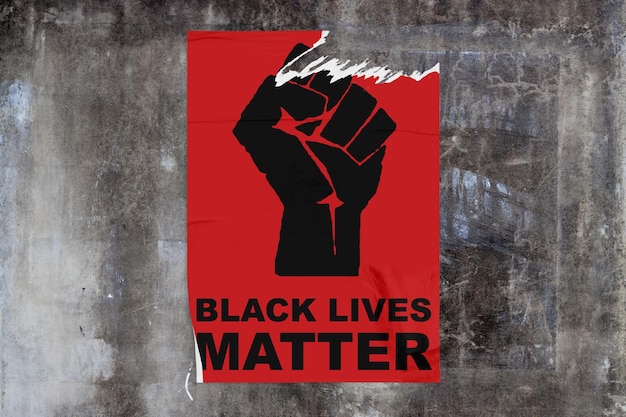 Betonwand mit einem zerrissenen roten Plakat, das eine schwarze Faust mit der Aufschrift „Black Lives Matter“ darstellt