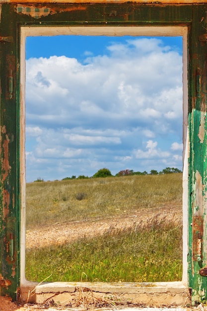 Betrachten Sie die Landschaft aus dem alten Fenster.