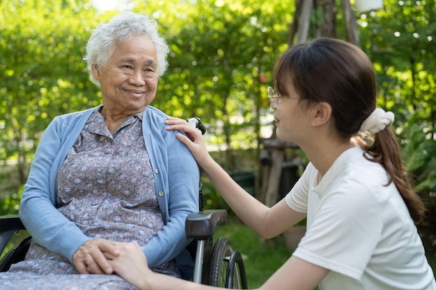 Foto betreuer hilfe und pflege asiatische senioren oder ältere alte dame patientin sitzt auf rollstuhl im park gesund stark medizinisches konzept