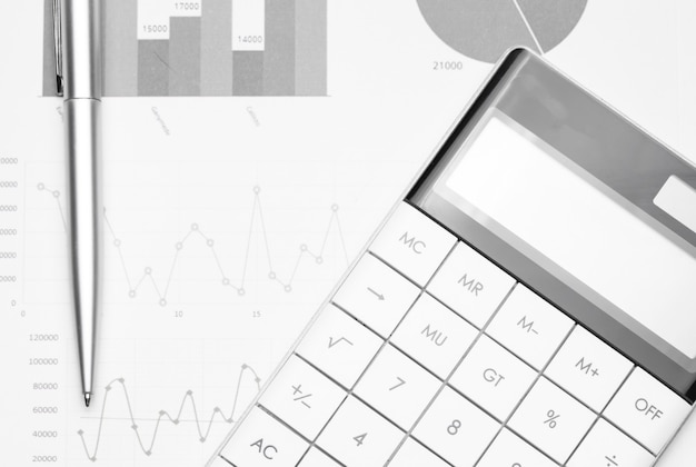 Betriebswirtschaftlicher Hintergrund mit Diagrammen, Stift und Taschenrechner