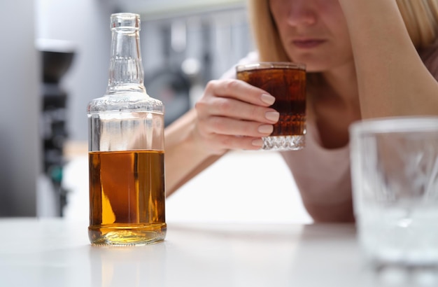 Betrunkene depressive Alkoholikerin trinkt allein zu Hause Whiskey