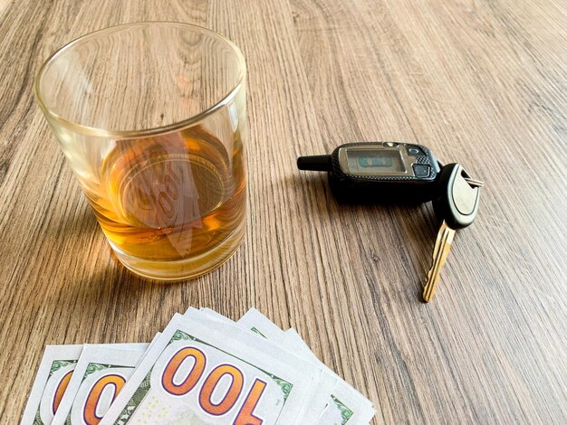 Betrunkenes Fahrkonzept Glas mit Whiskey und Autoschlüssel auf dem Tisch