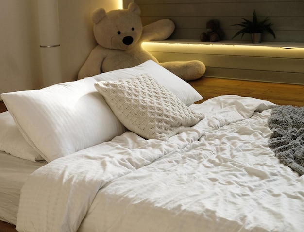 Bett im Schlafzimmer mit weißen Kissen und kuscheliger Bettwäsche aus nächster Nähe
