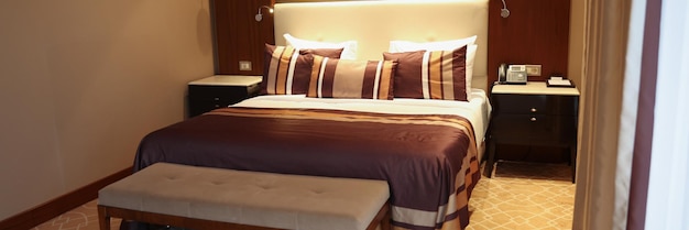 Bett mit brauner Bettwäsche im Hotelzimmer