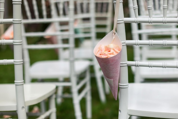 Beutel mit Rosenblättern auf dem Chiavari-Stuhl Viele Stühle im Hintergrund