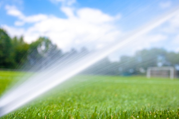 Bewässerung mit Hilfe von Druckdüsen mit Wasser im Fußballstadion