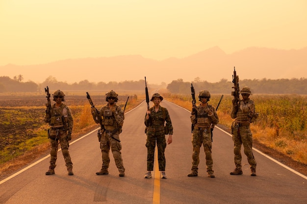 Foto bewaffnete streitkräfte stehen beim sonnenuntergang gegen den himmel